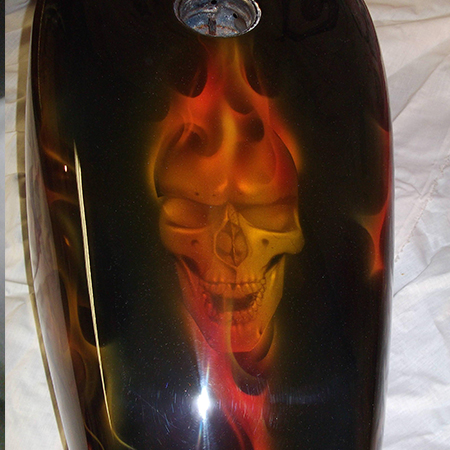 custom painted motorcycle gas tank with airbrushed skulls and flames