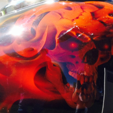 custom painted motorcycle gas tank with airbrushed skulls and flames