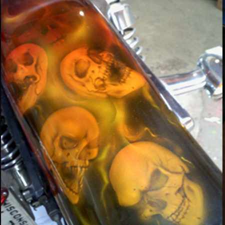 custom painted motorcycle gas tank with airbrushed skulls and flames