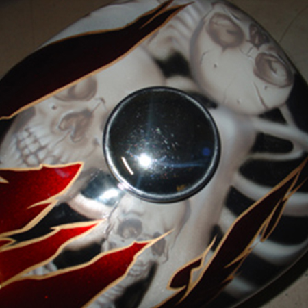 custom painted motorcycle gas tank with airbrushed skulls