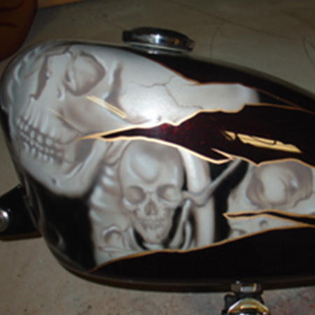 custom painted motorcycle gas tank with airbrushed skulls