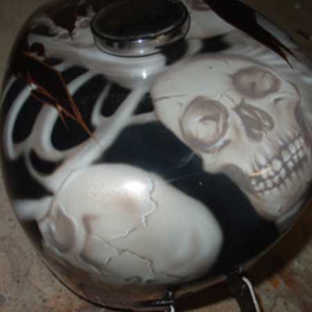 custom painted motorcycle gas tank with airbrushed skulls